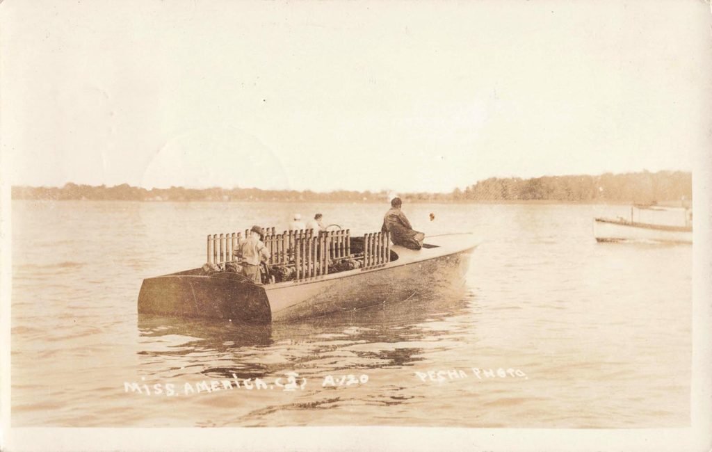 Vintage boat with passengers on water.