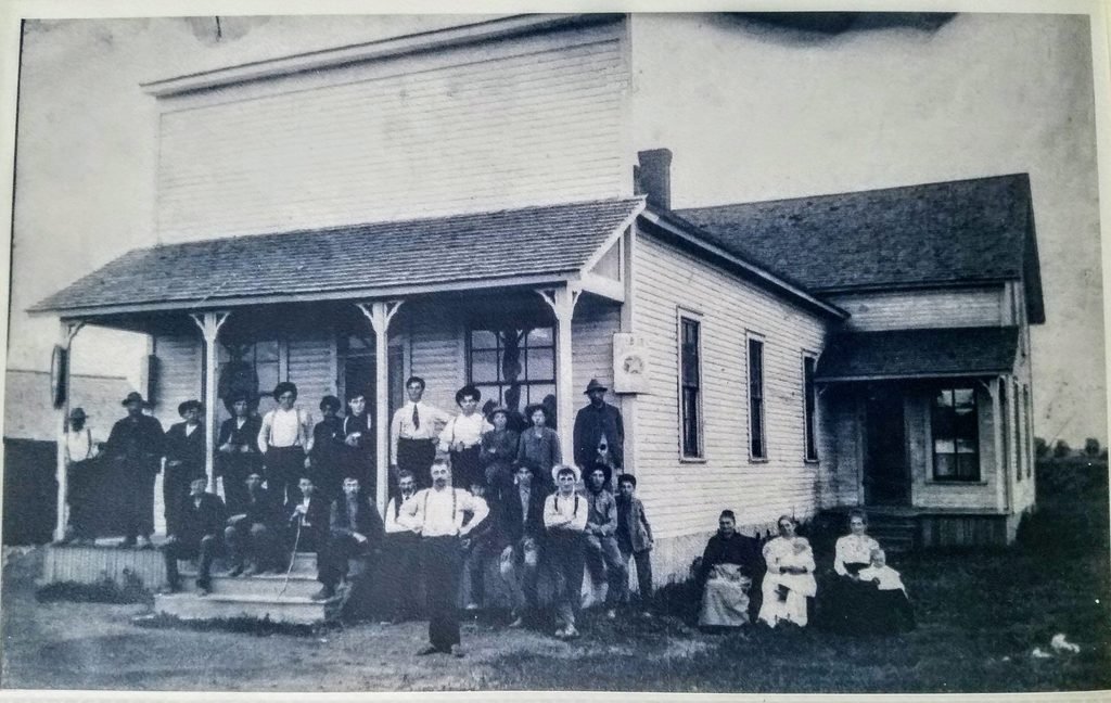 Historic group photo in front of building.