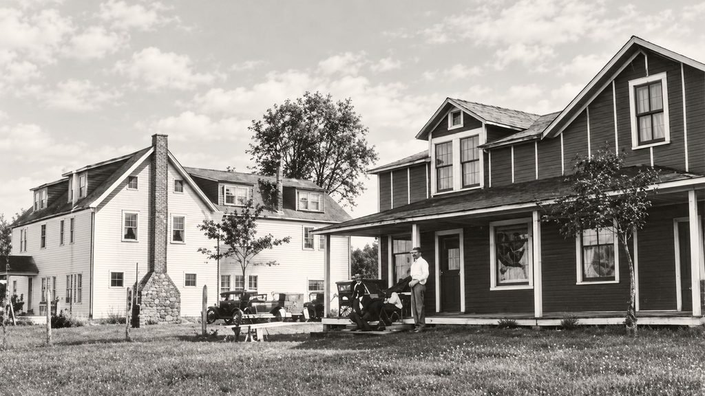 An exterior postcard identifies the inn and post office together. A local postal-history page labels the scene as the 1930s. The arrangement links resort services with the community mail.