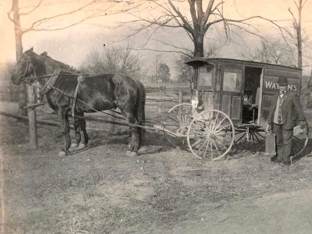Horse-drawn wagon with salesman standing.