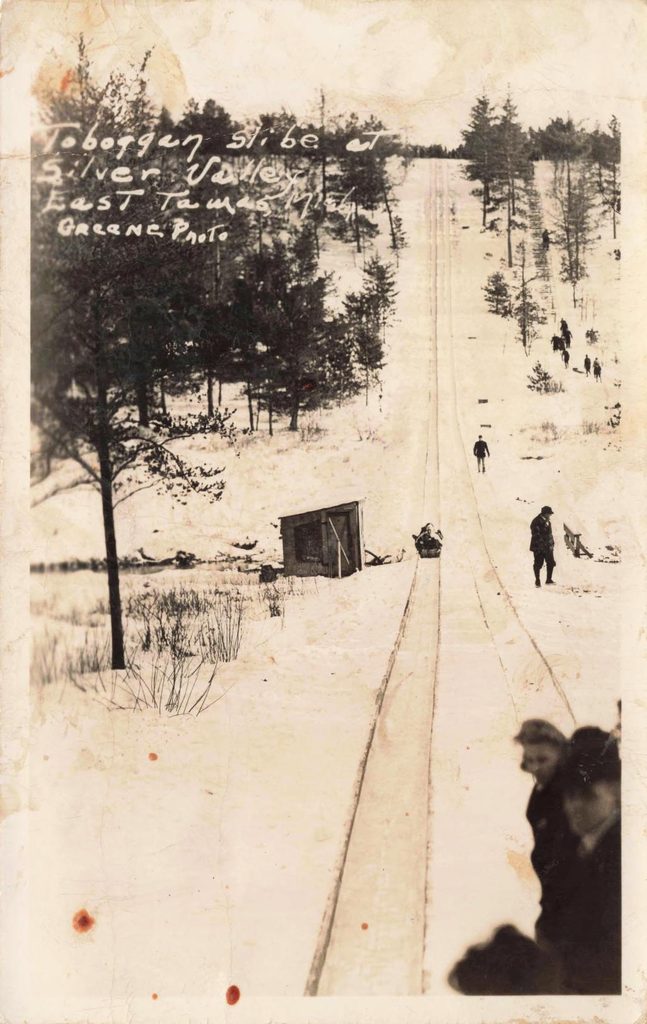 History of Silver Valley - Snowy hill with sledding activity.