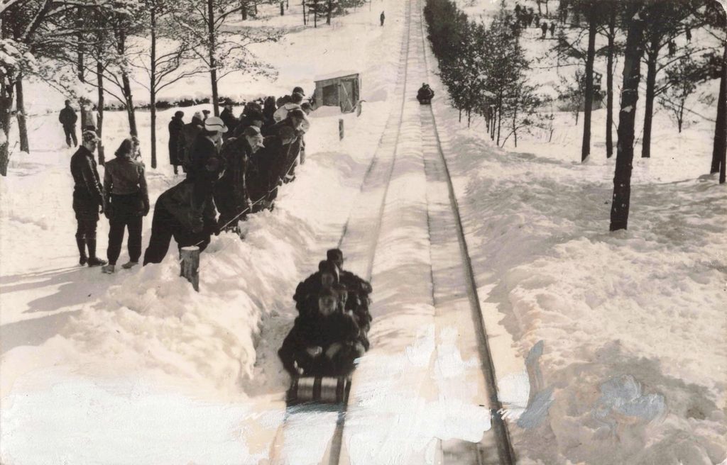 People sledding down a snowy hill.
