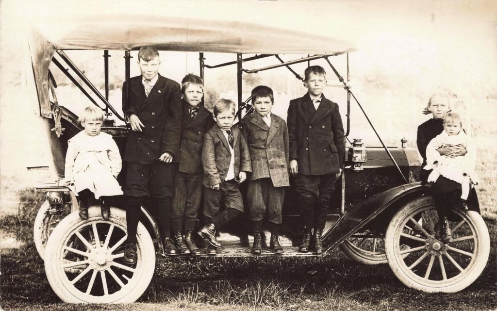 Group of children by vintage car
