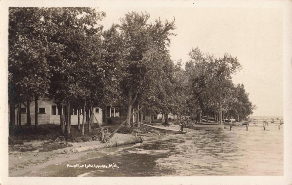 Lakeside view with boats and trees.