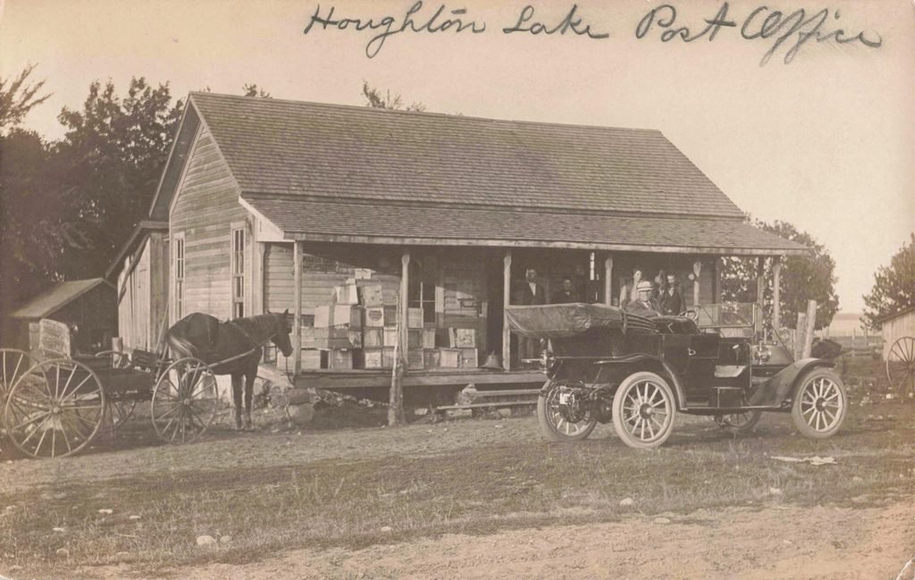 Historic Houghton Lake Michigan post office with early automobile and horse-drawn wagon