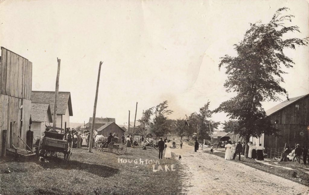 Early 1900s Houghton Lake Village, Michigan dirt street with residents and horse-drawn wagons